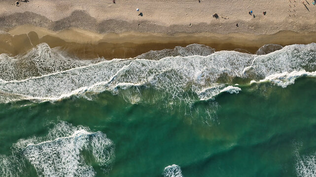 Aerial view of beautiful sandy beach with crashing waves and serene ocean, Ze Amandio, Bombinhas, Brazil.