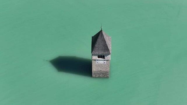 solitary Campanile di Curon Venosta stands amidst turquoise waters in Italy