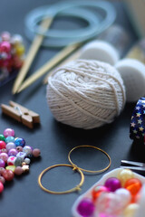 Colorful beads, coloring pencils, glitter, needles, string, hoop, tape and scissors on dark...