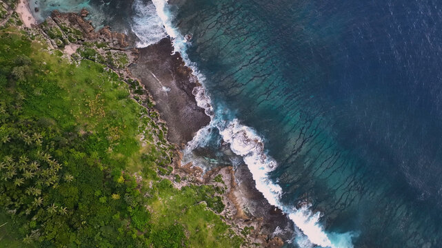 Aerial view of tropical island with lush greenery and beautiful reef, Utulau, Tonga.