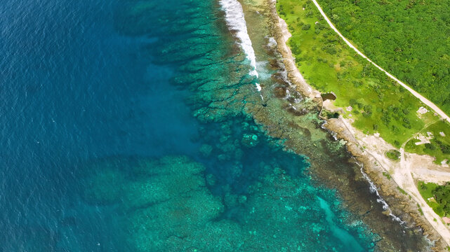Aerial view of a beautiful tropical island with turquoise water, lush palms, and waves, Shefa, Vanuatu.