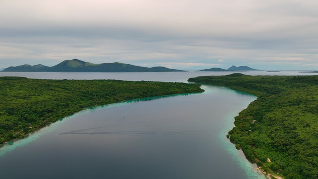 Aerial view of a tropical island with lush greenery, pristine reef, and azure ocean waves, Shefa, Vanuatu.
