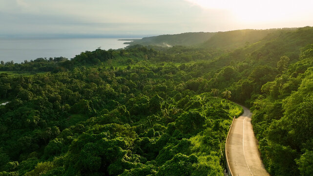 Aerial view of a curvy road through lush tropical forest at sunset, Mele Maat, Vanuatu.