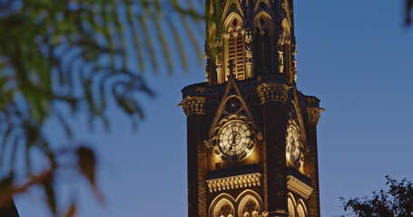 Close-up view on Rajabai Clock Tower In Evening Illumination. Clock Tower In Mumbai India. Confines...