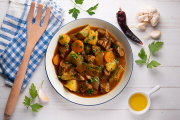 Beef stew with potatoes and artichoke. Top view table with  decoration.