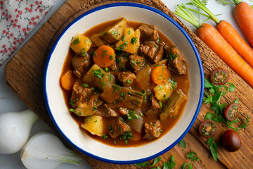 Beef stew with potatoes and artichoke. Top view table with  decoration.