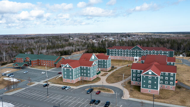 Aerial view of cape breton university campus with beautiful buildings and green roofs surrounded by forest, Grand Lake Road, Canada.