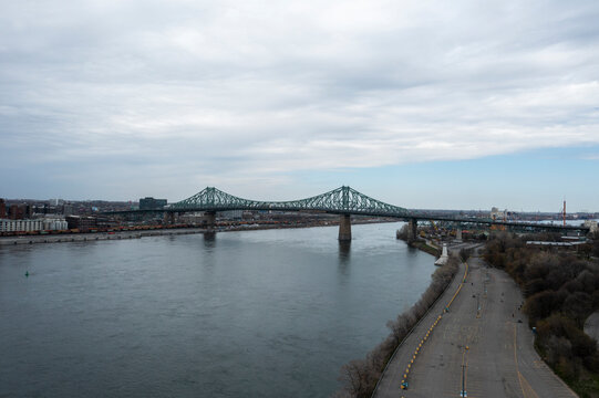 Aerial view of the iconic jacques cartier bridge over the serene saint lawrence river with a picturesque cityscape of old montreal, montreal, canada.