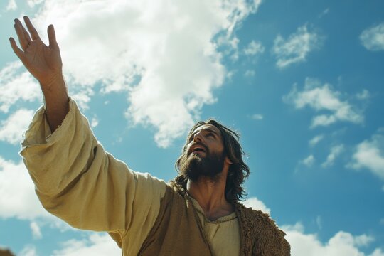 Jesus Christ is reaching up to the sky. The sky is blue and there are clouds in the background
