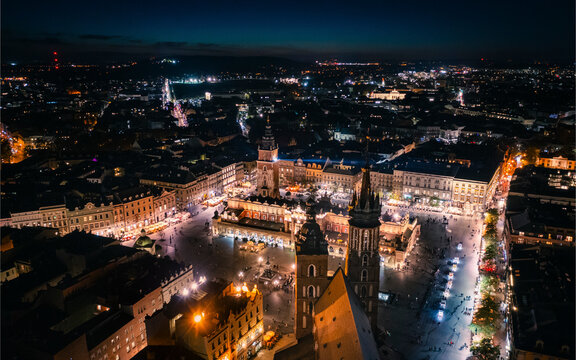 Aerial view of the illuminated Main Square featuring St. Mary's Church and Sukiennice, Krakow, Poland.
