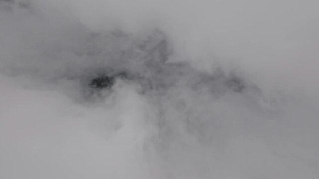 Video footage. Picturesque aerial view from airplane window on white cloud moving inside. Abstract smoke cloud, fast movement, clouds moving forward towards camera, drone flight from below