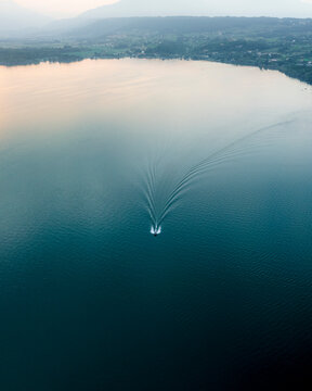 Aerial view of serene Viverone Lake with boats and reflections, Viverone, Italy.