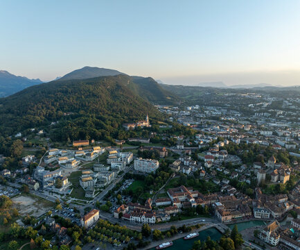 Aerial view of basilique de la visitation surrounded by charming houses and picturesque mountains, Bonlieu, France.