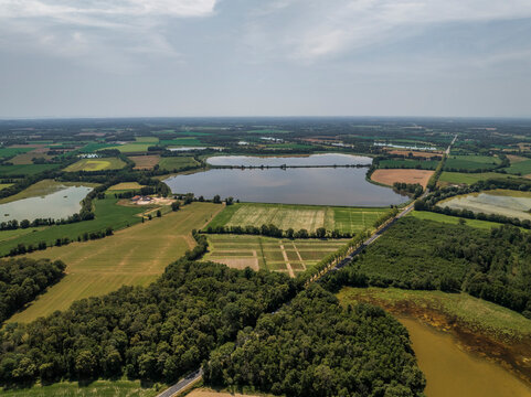 Aerial view of beautiful tranquil Parc des Oiseaux with expansive fields, serene lakes, and lush forests, Saint-Paul-de-Varax, France.