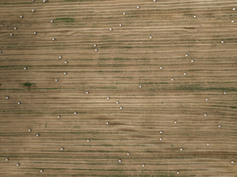 Aerial view of a beautiful haystack field with golden straw in the scenic countryside, Varennes-Saint-Sauveur, France.