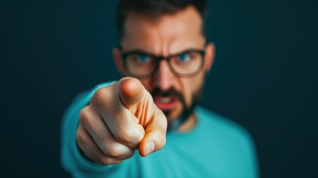 Close up of a man angrily pointing his finger during a heated argument or confrontation with a blurred background creating a deep depth of field effect