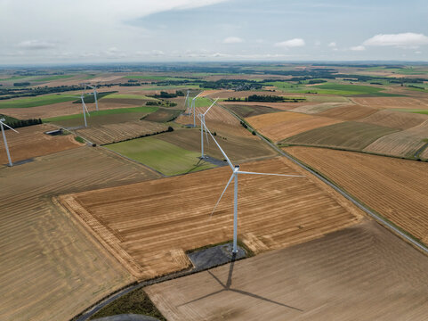 Aerial view of wind turbines above green fields in rural landscape, Son, France.
