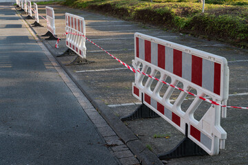 Temporary road closure barriers line an unused parking area