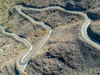 Aerial view of winding roads on the west coast of Gran Canaria, the least urbanized coast. Province of Mogan. Desert land with little vegetation, mountains alternate with sparsely inhabited valleys.
