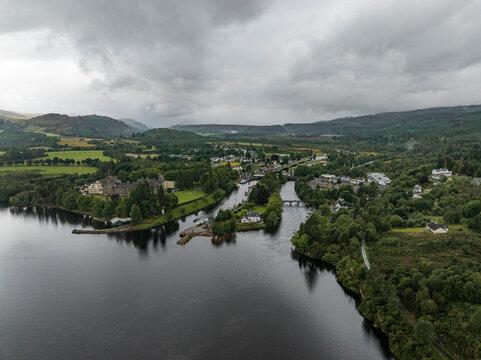 Aerial view of serene Loch Ness surrounded by lush hills and a picturesque village, Fort Augustus, Scotland.