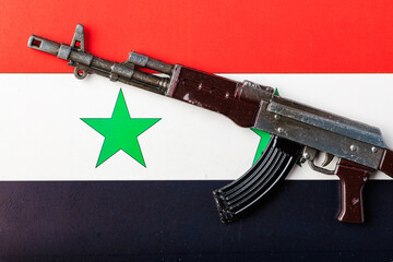 A toy gun is placed on Syria flag