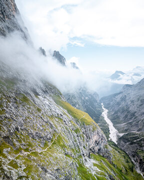 Aerial drone view of a Mountain Vally in The Dolomites filled with clouds, Province of Trento, South Tirol, Italy