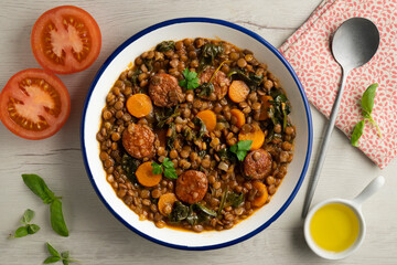 Lentil stew with chorizo, spinach and carrot. Top view table with  decorations.