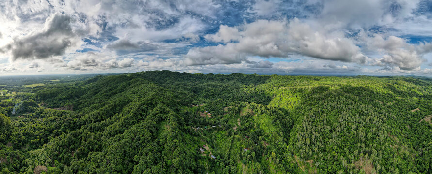 Aerial view of lush green hills and tranquil forests under a cloudy sky, Chittagong, Bangladesh.
