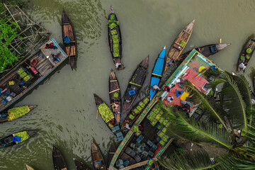 Aerial view of floating guava market with boats and people along the river, Barishal, Bangladesh.