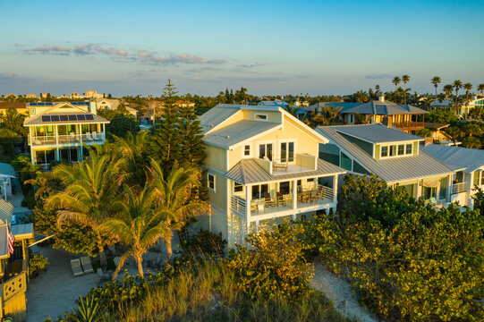 Saint Pete Beach, United States - 24 March 2019: Aerial view of luxurious beach house surrounded by palm trees and ocean view at sunset, Saint Pete Beach, United States.