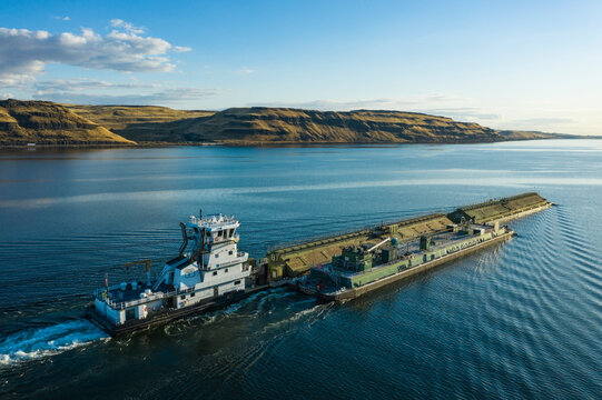 Aerial view of tranquil river barge and tugboat on the serene Columbia River Gorge, Benton County, United States.