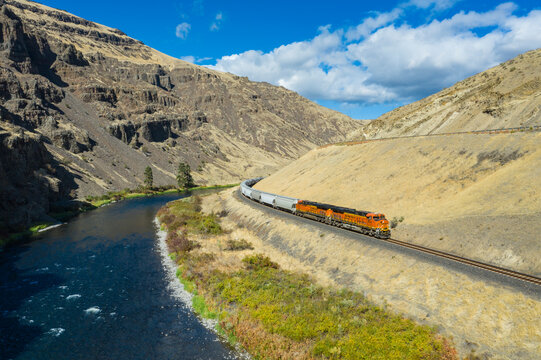 Aerial view of the scenic Yakima River winding through the beautiful Yakima Valley with BNSF Railway tracks and rugged mountains, Kittitas County, United States.