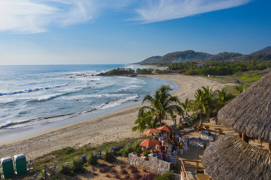 Aerial view of beautiful tropical beach with palm trees and thatched roof hut, Troncones, Mexico.