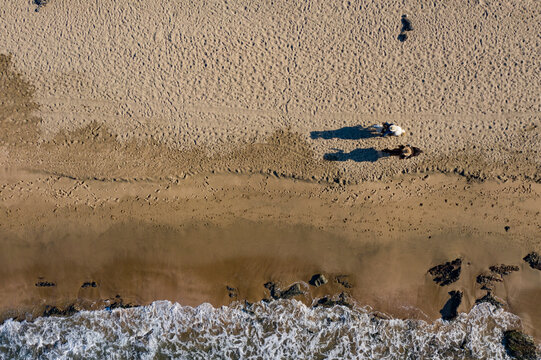 Aerial view of tranquil Playa Troncones beach with a horse casting a shadow on the sand, Troncones, Mexico.