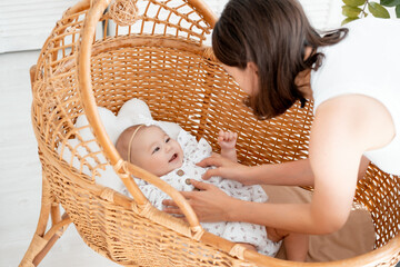 mom puts the baby to sleep in a bright bedroom, healthy baby sleep