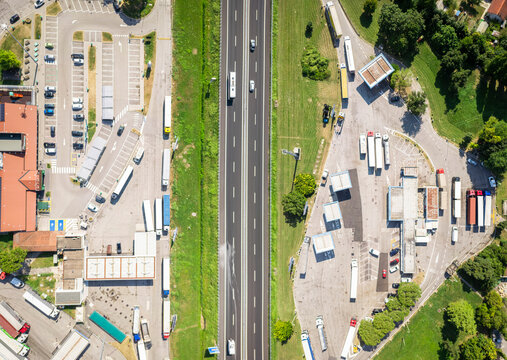Aerial view of a busy highway with trucks and a gas station, Santa Maria di Campagna, Cessalto, Italy.