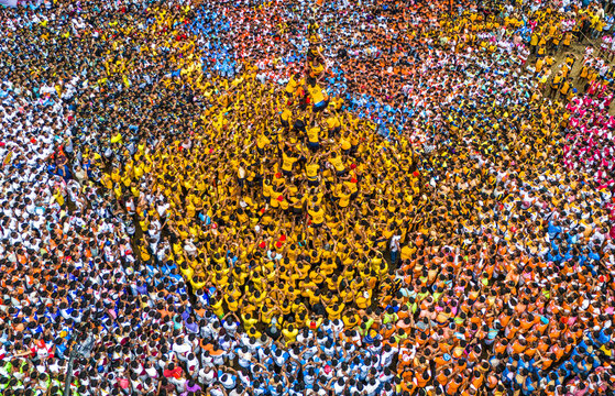 Aerial view of vibrant dahi handi festival with colorful crowd celebrating in traditional attire, Thane, India.