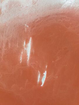 Aerial view of serene and colorful salt flats with abstract patterns and textures, Aigues-Mortes, France.