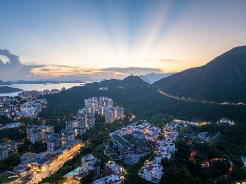Aerial view of breathtaking cityscape with modern skyscrapers and mountains at sunset, Chung Hom Kok, Hong Kong.