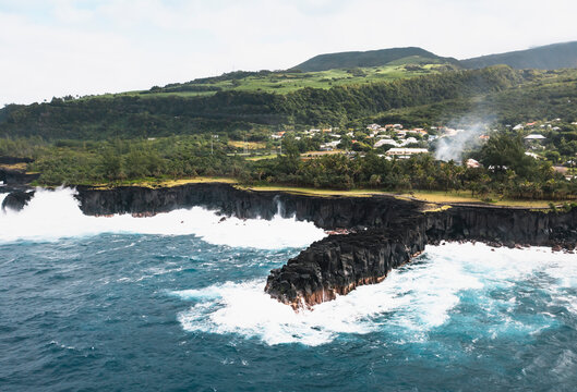 Aerial view of stormy waves crashing against rough cliffs at Puits des Francais, Saint-Philippe, Reunion.