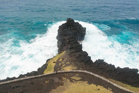 Aerial view of rugged cliffs and crashing waves with mist, Puits des Francais, Saint-Philippe, Reunion.