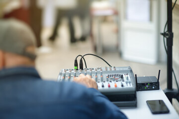Audio Technician Adjusting Mixing Console at Live Event