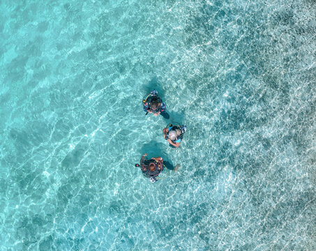 Aerial view of people scuba diving in clear blue ocean, Vashafaru, Maldives.