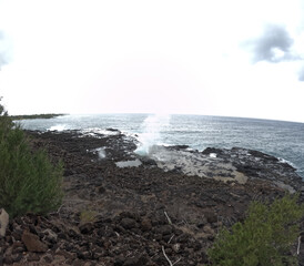 Spouting Horn blowhole against bright blue tropical ocean in Kauai, Hawaii