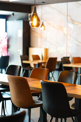 Cozy and modern coffee shop interior with wooden furniture, warm lighting, and large windows overlooking the street, creating an inviting atmosphere