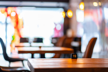 Cozy and modern coffee shop interior with wooden furniture, warm lighting, and large windows overlooking the street, creating an inviting atmosphere