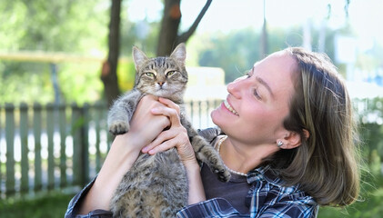 Close-up of adorable cat and woman, who is stroking animal, expressing love and care. Cute pet and loving owner person.