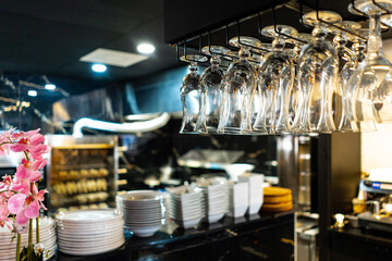 Row of the upturned crystal wine glasses on bar table