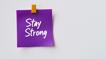 Sticky Note: A single violet sticky note with the words "Stay Strong" written in simple, clear handwriting. The sticky note is placed on a plain white background, offering support and encouragement.