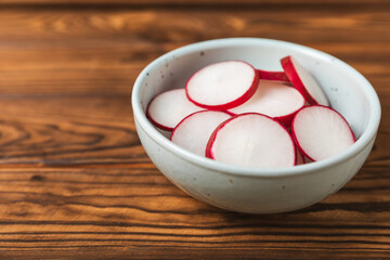 Fresh radish on textured wooden background. Organic natural garden radish slices. clipping root crop. Vegetables. Vegan. Diet products. Healthy food. Place for text. Copy space.